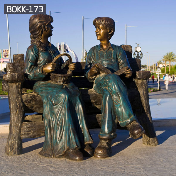 Outdoor park garden decor girl and boy sitting on the bench talking bronze sculpturesOutdoor park garden decor girl and boy sitting on the bench talking bronze sculptures