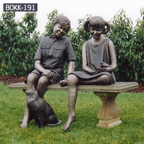 Boy and girl sitting on the bench talking with a cat bronze sculptures outdoor