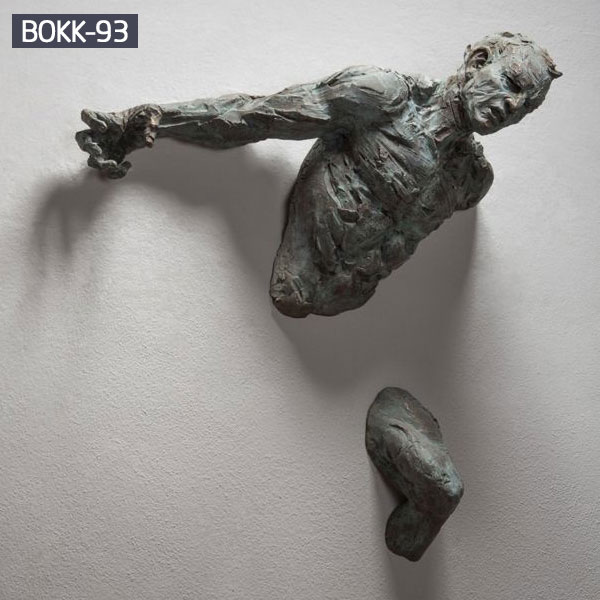 Bronze man coming out of wall sculpture for sale